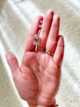 Load image into Gallery viewer, Hand holding two pair of white shiny stud earrings