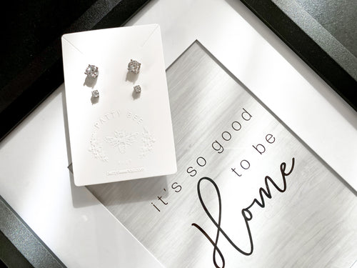 Jewelry card with two sets of white zirconia stud earrings on top of a quote that says: 